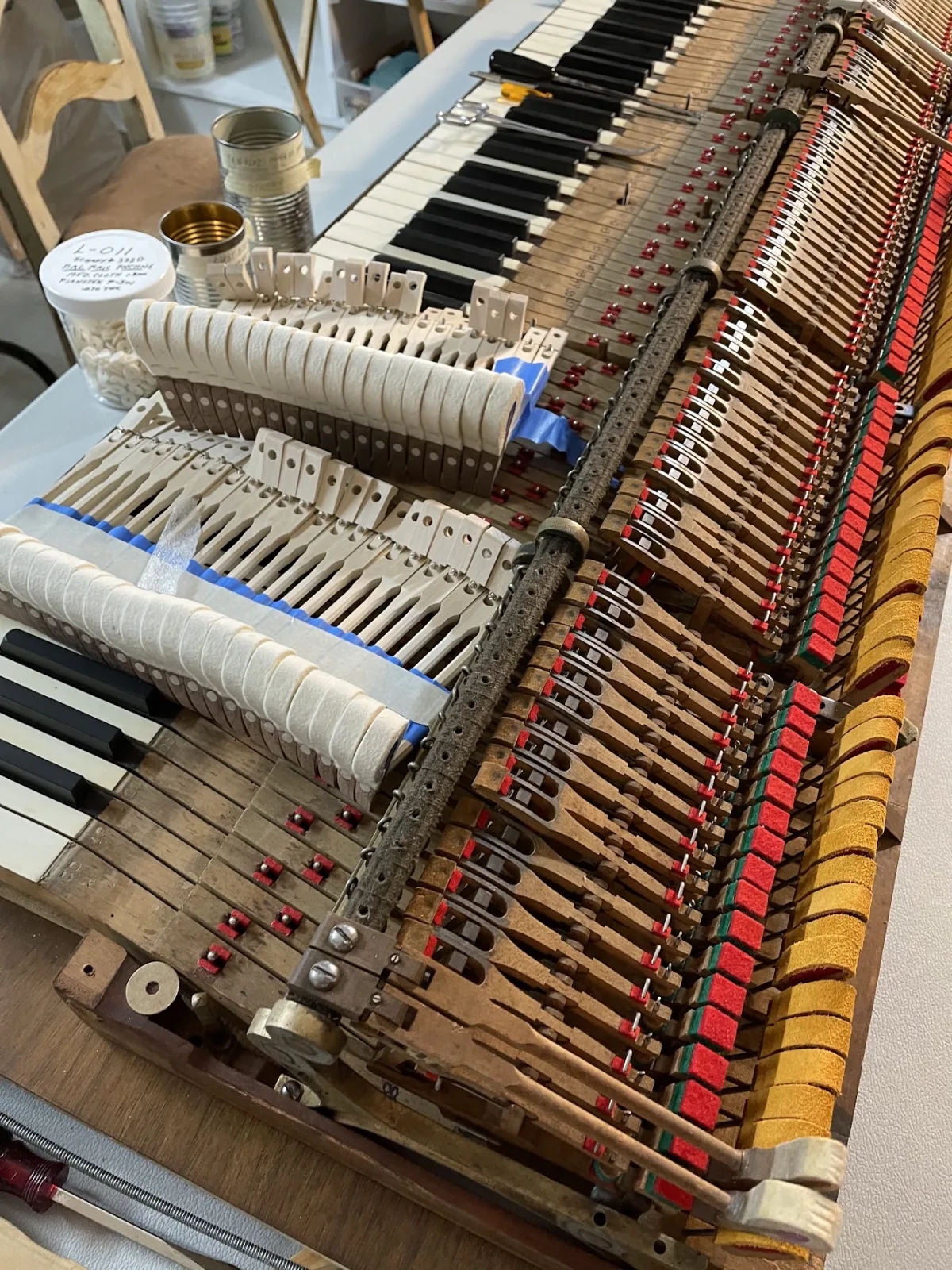 Upright piano action fully exposed during rebuild